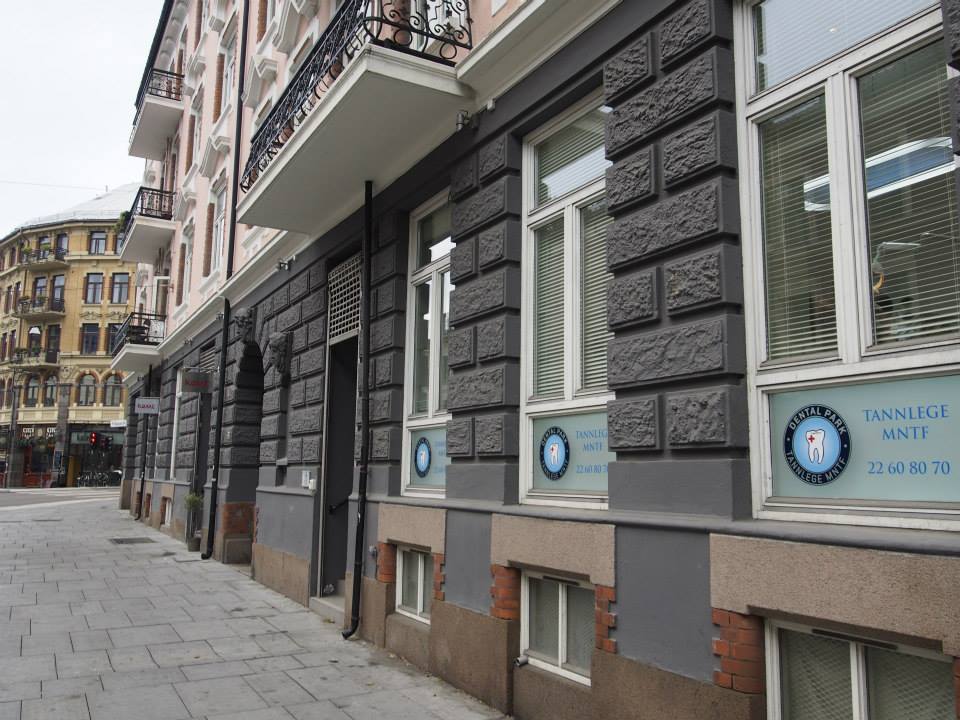 Utendørsbilde av tannlegeklinikken Dental Park i en klassisk bygård med grå murvegg. Skiltet markerer inngangen fra gatenivå i krysset mellom Hegdehaugsveien og Parkveien.